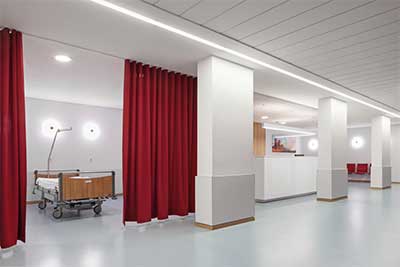 Thumbnail of a full installation of the Silent Gliss 100 universal curtain track system in what looks like an empty hospital ward without beds. There's a nice wooden floor too. It makes me want to buy the curtain tracks. Good job Silent Gliss.